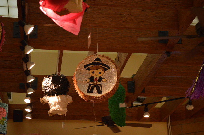 A variety of piñatas hang from the wooden beams in Smoky Hill Library on Sept. 14.